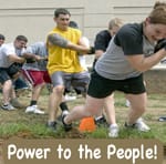 Adult multiethnic tug of war, with the words "Power to the People" underneath