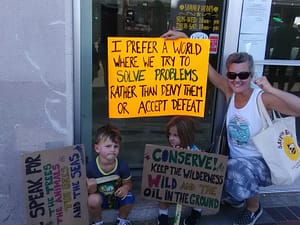 A mom and her young son and daughter holding their Climate Strike signs on Oceanside, California's busiest street corner.